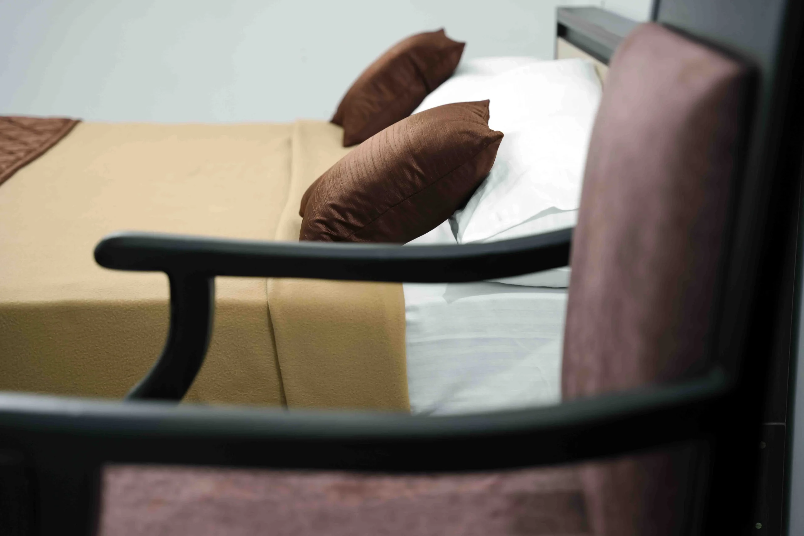 Comfortable and modern hotel room at Gold Suite Kakkanad featuring beige bedding and brown cushions — premium rooms near Infopark for a relaxing stay