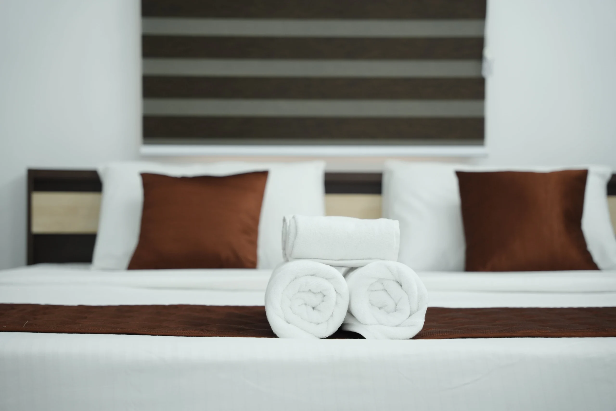 Neatly arranged deluxe room at Gold Suite Kakkanad with soft white towels and elegant bedding near Infopark Kochi.