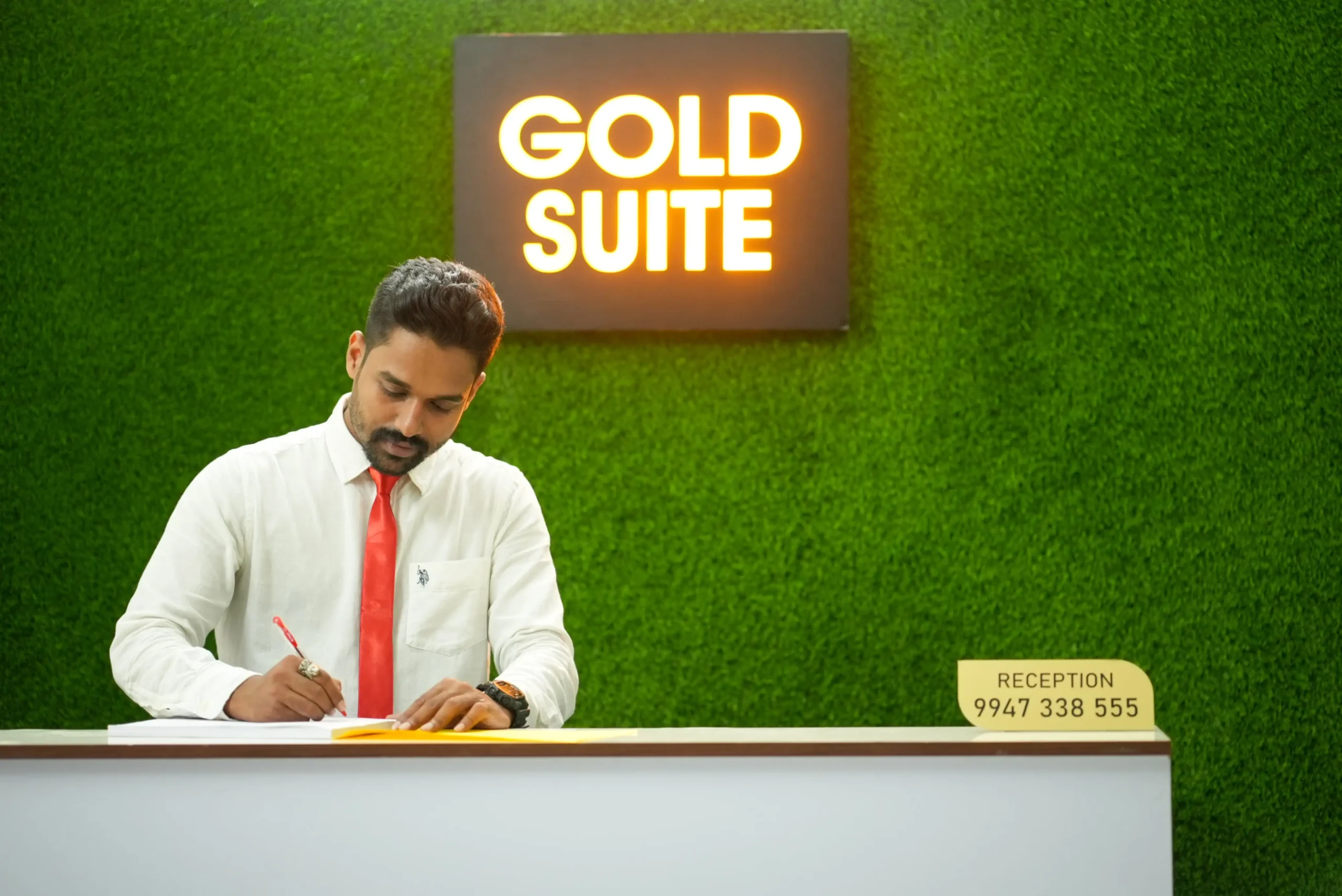 Reception desk at Gold Suite Kakkanad with friendly staff providing assistance — best hotel rooms near Infopark with warm hospitality.