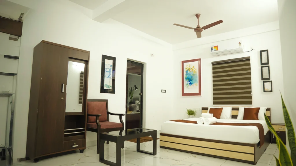 Premium Room at Gold Suite Kakkanad featuring elegant interiors, modern furniture, and cozy bedding for guests seeking a premium room in Kakkanad.