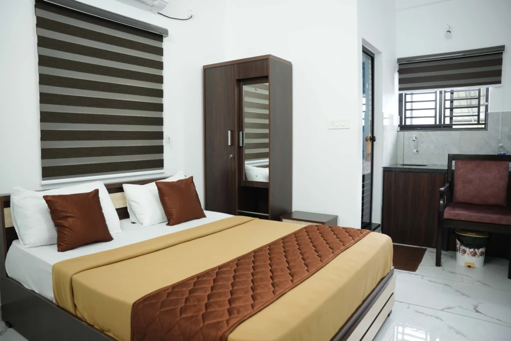 Standard room at Gold Suite Kakkanad featuring modern interiors and comfortable bedding