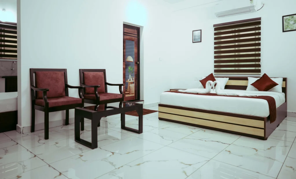 Modern suite room at Gold Suite Hotel in Kakkanad with king-size bed, elegant seating area, and cozy interiors